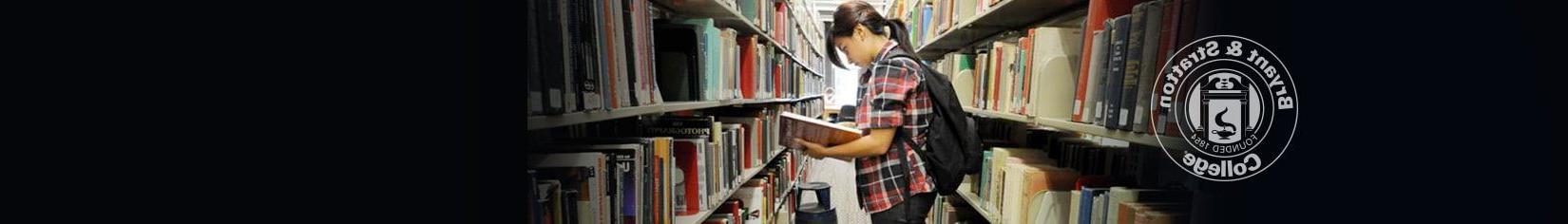 Student in library searching for books